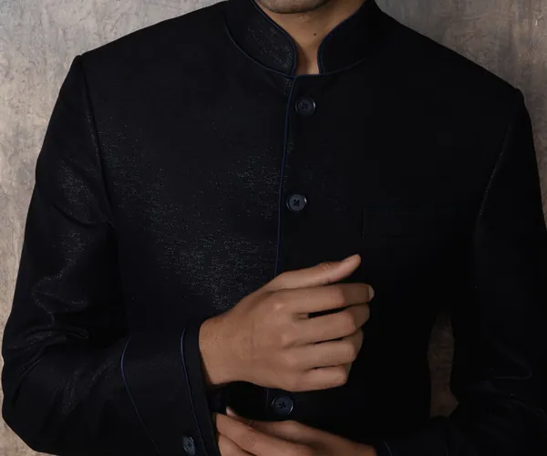 The front: Closed on self buttons · a tonal jacquard, in black.