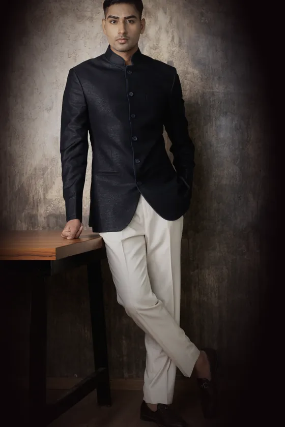 The black bandhgala, closed at the collar, worn with ivory trousers