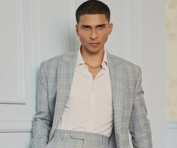 The check: Grey windowpane · notch lapel, worn with an open collar.