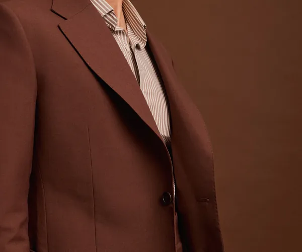 The lapel: Notch lapel and patch pocket · two buttons, in chocolate.