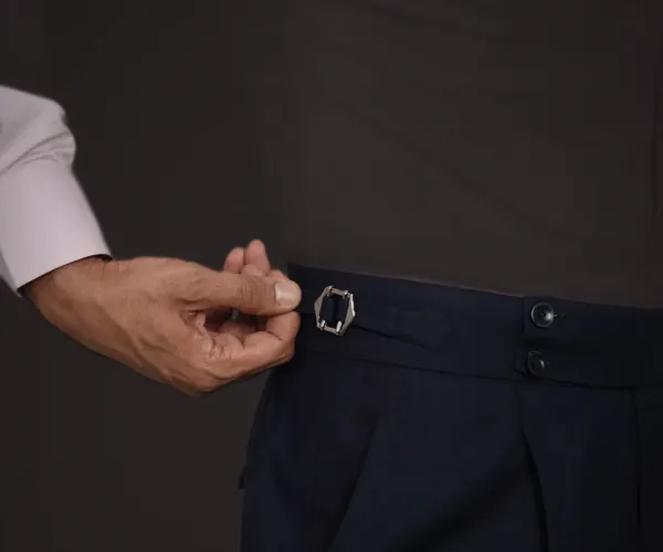 The side adjuster: Buckled side adjuster on a two-button waistband · pleated front, in navy.