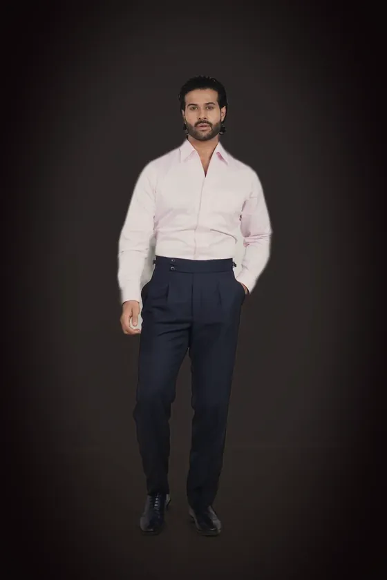 The navy pleated trousers with side adjusters, worn with a pale pink shirt